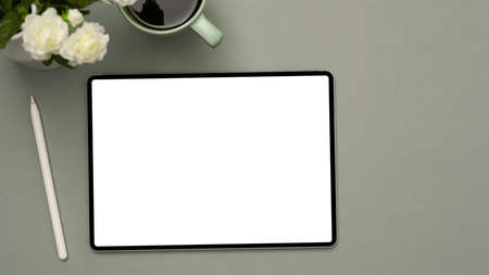 Minimal office table background with digital tablet touchpad white screen mockup, stylus pen, coffee...