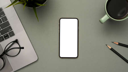 Top view, A modern office desk with office supplies and a smartphone white screen mockup on grey background.の写真素材