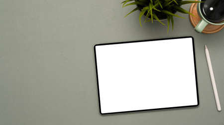 Simple grey workspace background with digital portable tablet white screen for display your banner mockup with accessories. top viewの写真素材