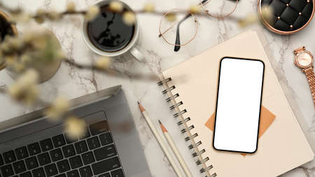 Modern female office desk with laptop computer, notepad, accessories and smartphone white screen...