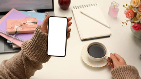 Relaxed woman in cozy brown sweater enjoy with her morning coffee and looking some online content on...