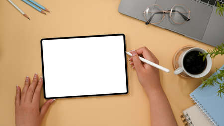 Female graphic designer sketching or making a graphic image on tablet computer in her stylish desk....