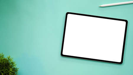 Workspace with digital tablet touchpad white screen mockup, stylus pen, decor plant and copy space...