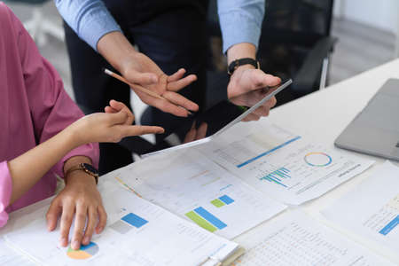 Two financial advisor discussing and planning financial investment and checking the report together.
