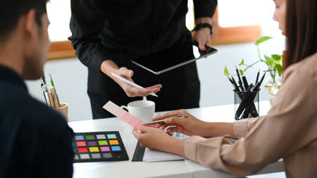 Group of graphic designers team having a meeting in the office, checking the latest interior plan.