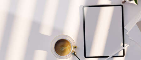 Top view, Digital tablet touchpad computer white screen mockup, coffee cup and copy space on white...