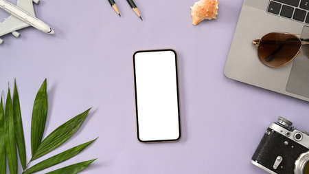 Modern purple workspace background with smartphone blank screen mockup, laptop, camera and accessories. top view, flat layの写真素材