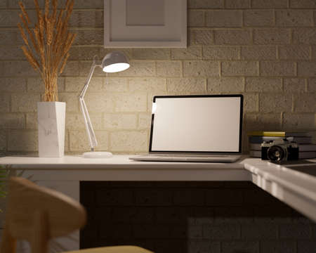 Close-up, Modern dark home office workspace with notebook laptop computer white screen mockup under...
