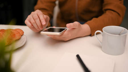 Hand of woman using smartphone on modern white table. typing, text, message on smartphone. close-up