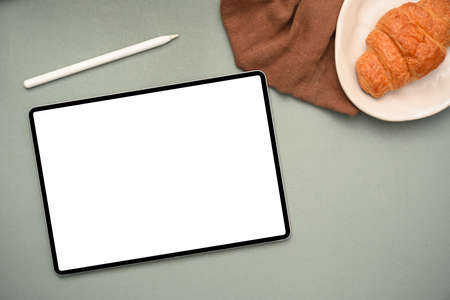 Overhead shot office workspace green background with wireless tablet touchpad blank screen mockup,...