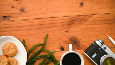 Overhead shot, A copy space for product display on wooden table background with camera, coffee cup, a plate of cookies and decor.の写真素材