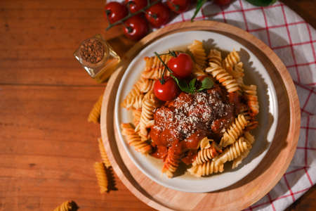 Above view, A plate of fusilli pasta with organic tomato sauce and parmesan cheese on vintage table.