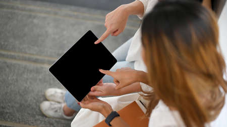 Close-up image and above view, Two asian college female students looking and pointing their finger...