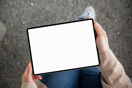 Top view, Female using portable digital tablet touchpad while relaxes in the park. clipping pathの写真素材