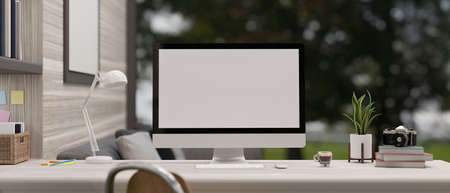 Home workspace with computer blank screen mockup and accessories on table in the comfortable and...