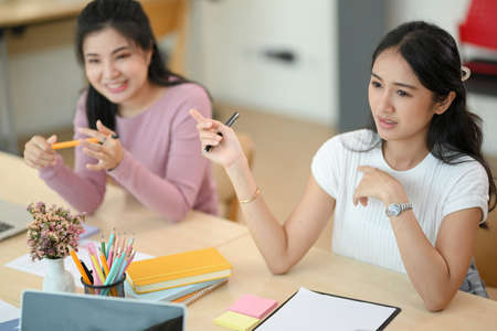 Beautiful Asian female financial assistant explaining the financial report in the meeting.