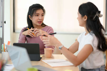 Professional female entrepreneur discussing with her marketing manager about the marketing strategy.の写真素材