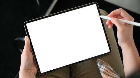 A woman hands holding stylus pen, drawing on digital tablet screen. Tablet white screen mockup.