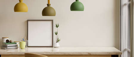 Modern minimalist home interior with home accessories, copy space and blank picture frame mockup on white tabletop against white wall under stylish colourful lamps. 3d rendering, 3d illustrationの写真素材