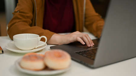 Cropped, closeup image, Female young worker using laptop computer, typing on keyboard in the office.の写真素材