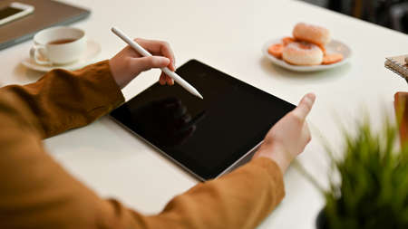 Close-up, Female college student or freelancer designing her art work on digital tablet touchpad.の写真素材