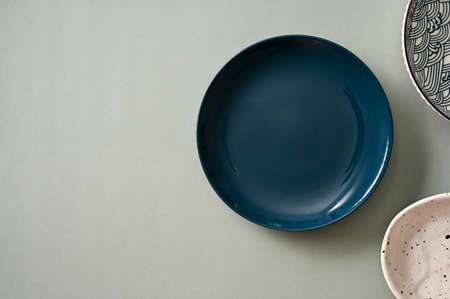 Minimal stylish dining table setting with minimal dark blue plate and handcraft ceramic plates on...