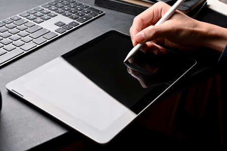 Close-up image, Male graphic designer using stylus pen designing his project on digital tablet at...