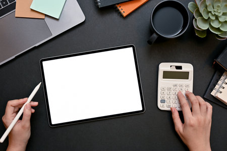 Top view, Businesswoman or female financial analysts using calculator and working on tablet computer...