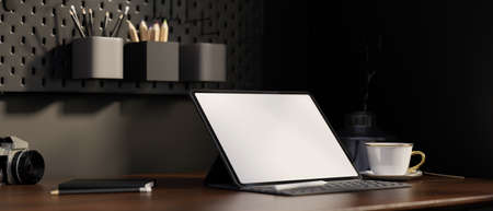Modern stylish dark workspace with tabletwhite screen mockup, coffee cup and accessories on dark...
