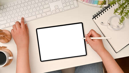 Top view, Flat lay, Female graphic designer using digital tablet computer designing her graphic work...