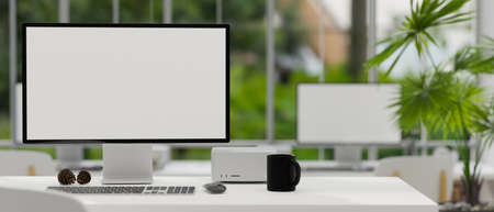 Modern open-office workplace interior with pc computer blank screen mockup and office accessories on...