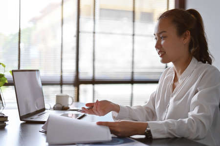 Attractive Asian businesswoman or business entrepreneur working in her private office, using laptop and checking the report.の写真素材