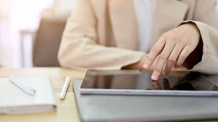 Woman taking a break in her living room, watching online content, using smartphone. cropped, closeupの写真素材