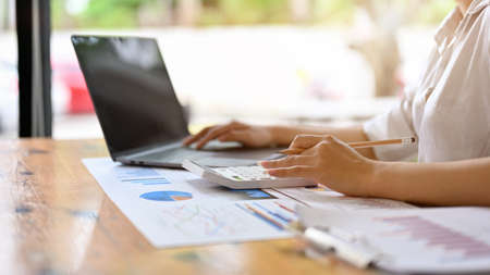 Rear view, close-up, Businesswoman or female accountant working on a financial report paperwork at...