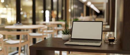 Modern comfortable coffee shop seating area interior design with laptop computer on wooden table....