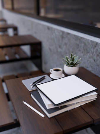 Digital tablet white screen mockup, book, pencil and coffee cup on modern outdoor wood table. Outdoor coffee shop seating area. close-up image, 3d rendering, 3d illustrationの写真素材