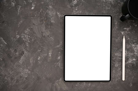 Modern workspace with digital tablet white screen mockup, stylus pen and copy space on grey grunge...