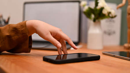 Close-up, A female touching on smartphone screen, using mobile phone, scrolling on social media via cellphone.の写真素材