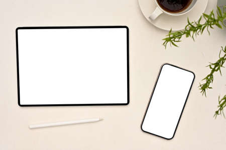Overhead shot, Digital tablet and smartphone white screen mockup, stylus pen, a cup of coffee and...