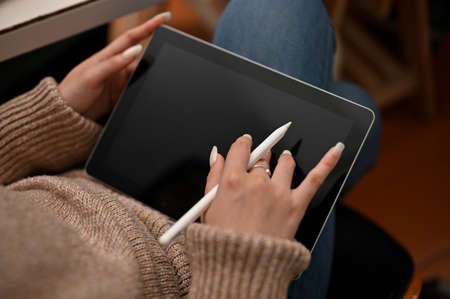 Relaxed female blogger create her online content and upload her content on the website via digital tablet. croppedの写真素材