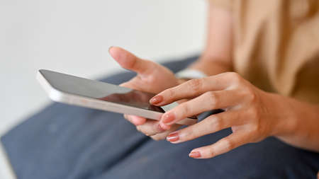 Close-up image, A female's hands using a modern smartphone to communicate with her friends....