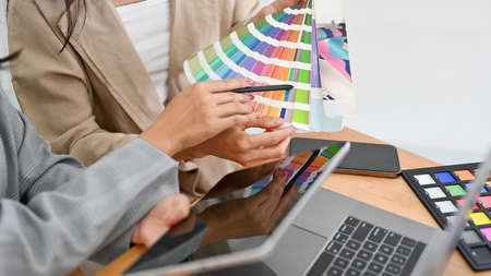 Two of a professional graphic designers are discussing and planning the web colour for their project...