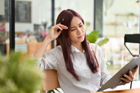Beautiful young asian businesswoman focused working on her work, pensive thinking the business plan...