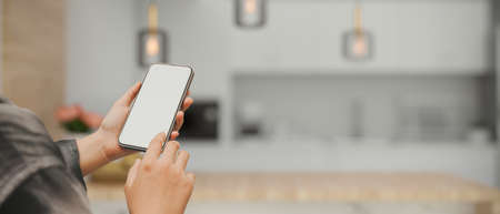 A mockup screen of a smart mobile phone or cellphone white blank screen in a woman's hand over...