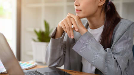 Thoughtful young asian businesswoman or female entrepreneur pensive thinking finding a business...