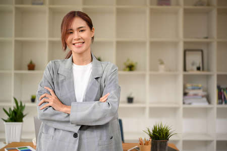 Portrait of a beautiful millennial asian businesswoman in casual suit standing in the office...