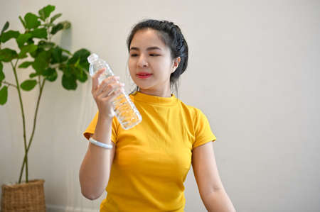 Healthy sporty millennial asian woman in sportswear with a water bottle in the modern yoga fitness.の写真素材