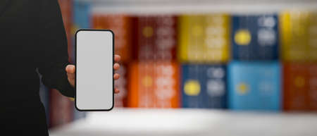 A female hand holding a smartphone white screen mockup over blurred warehouse with containers in the background. 3d rendering, 3d illustrationの写真素材