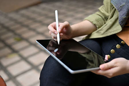 Close-up image, A female using a digital tablet touchpad, using stylus pen to design her graphic artwork.の写真素材