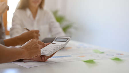 Close-up image, A male accountant or financial worker using a calculator to calculate a financial...